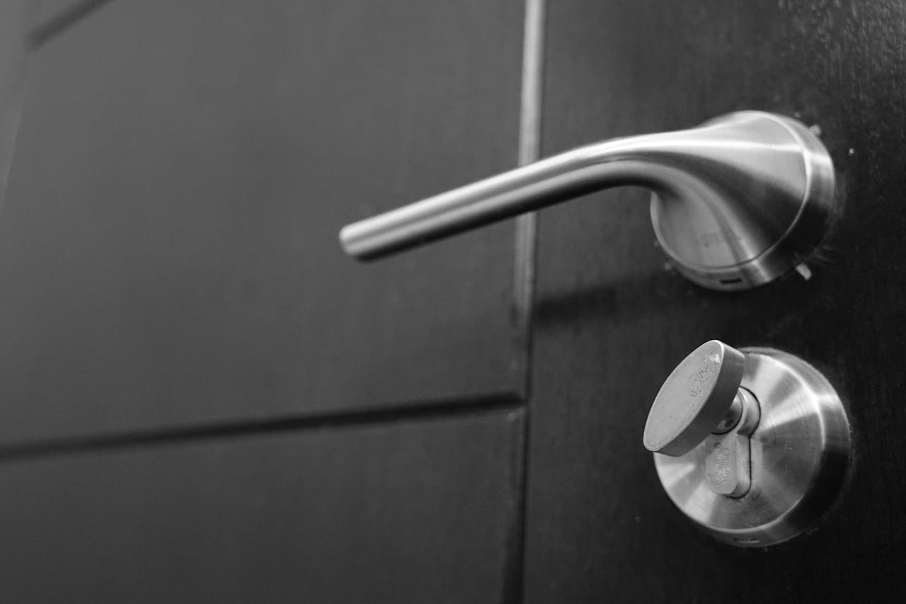 Black and white photo capturing a sleek stainless steel door handle with a focus on style and security.